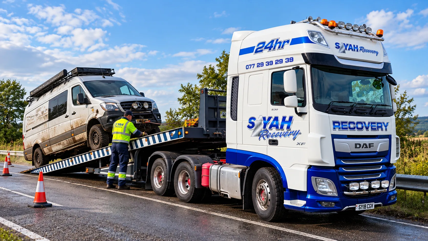 Recovery truck loading a broken-down van at the roadside